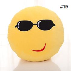 a yellow smiley face pillow with sunglasses on it