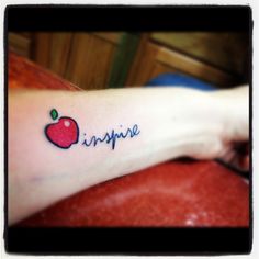 an apple tattoo with the word inspire written on it