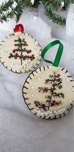 two decorated christmas cookies sitting on top of snow