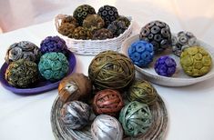 there are many different types of balls in the bowl on the table, and one is made out of yarn