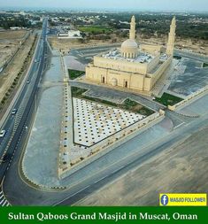 an aerial view of a large building in the middle of a desert with cars driving around it