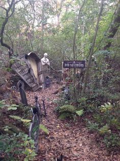 an old truck sitting in the woods next to a sign that says out and territory