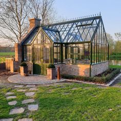 a glass house sitting on top of a lush green field