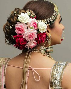 a woman with flowers in her hair is wearing an elaborate headdress and jewelry