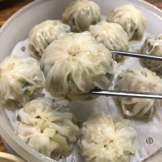 some dumplings are being held up by tongs