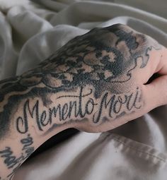 a person with a tattoo on their arm that says mermetatourium in black ink