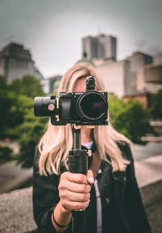 a woman holding a camera in front of her face