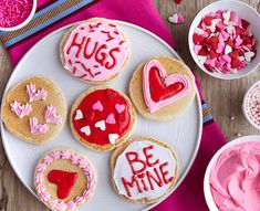 valentine's day cookies decorated with pink icing and hearts on a white plate