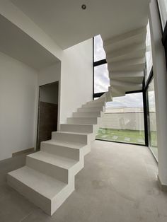 a white staircase leading up to a large window