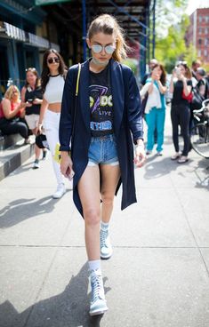 a woman walking down the street in short shorts