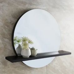 there is a mirror and vase on the shelf in front of this wall mounted mirror