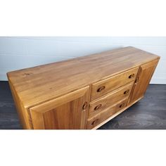 a large wooden dresser sitting on top of a hard wood floor next to a wall