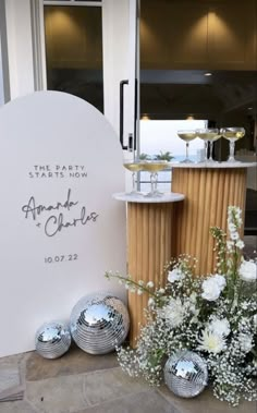 the table is set up with silver balls and flowers