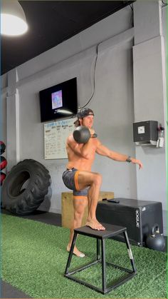 a man standing on top of a stool in front of a tv screen and another man behind him