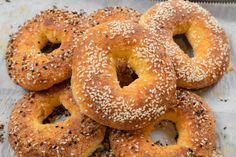 sesame seed bagels are piled on top of each other, ready to be eaten