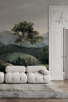 a white couch sitting in front of a painting on the wall next to a doorway