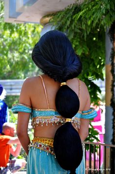 two women with long black hair are dressed in belly wraps and headdress