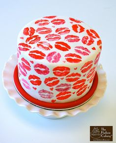 a white cake with red and pink lipstick on it sitting on top of a plate