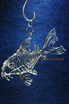 a metal fish is hanging from a hook on a blue background with the word,'fishing