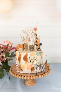 a cake with animals on it sitting on top of a table