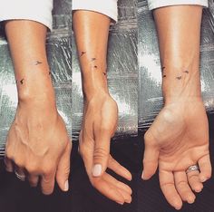 two hands with small tattoos on them