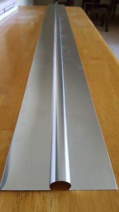 a close up of a metal strip on a wooden table