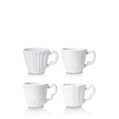 four white coffee cups sitting next to each other