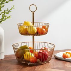 three tiered metal fruit basket with apples, oranges and pears in it