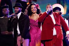 a group of people standing on top of a stage with microphones in their hands