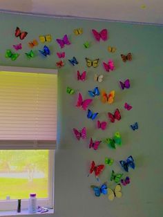 there are many colorful butterflies on the wall