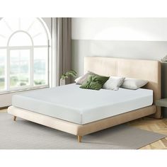 an image of a bed with a white mattress in the middle and green pillows on top