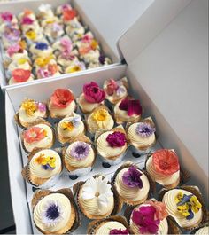 there are many cupcakes in the box and one is decorated with flowers on it