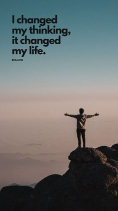 a man standing on top of a mountain with his arms outstretched