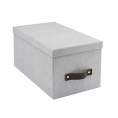 a grey storage box with leather handles on the top and bottom, sitting against a white background