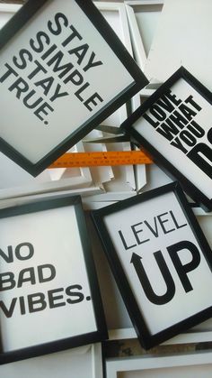 four framed signs with words on them and a tape measure in the middle one says, no bad vibes level up