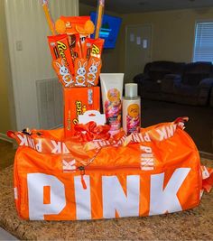 an orange duffle bag filled with different types of candy and toothbrushes sitting on top of a counter