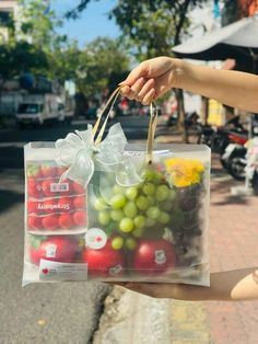 a person holding a plastic bag full of fruit