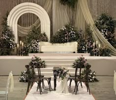 a wedding ceremony setup with chairs and flowers on the aisle, in front of an altar