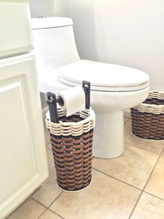 two wicker baskets sit next to a toilet in a bathroom with tile flooring