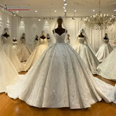 dresses are displayed on mannequins in a room with chandeliers hanging from the ceiling