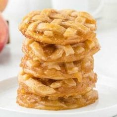 a stack of apple pie cookies sitting on top of a white plate next to an apple