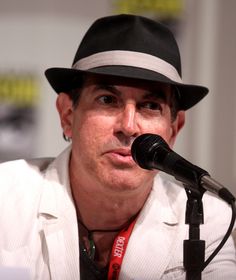 a man in a hat is speaking into a microphone