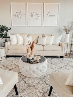 a living room with couches, chairs and two pictures on the wall above them