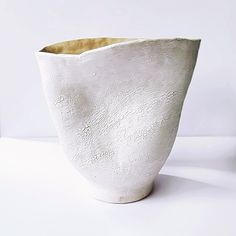 a white vase sitting on top of a table