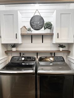 a washer and dryer in a laundry room with white cabinets on the wall