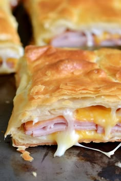 ham and cheese pastry is cut in half on a baking sheet, ready to be eaten