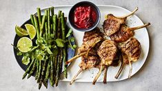 grilled chicken and asparagus on a plate with dipping sauce