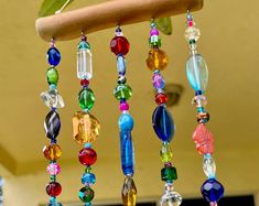 colorful beads hanging from a tree branch on a sunny day