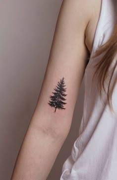 a small pine tree tattoo on the arm