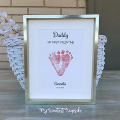 a baby's hand and foot print in a gold frame